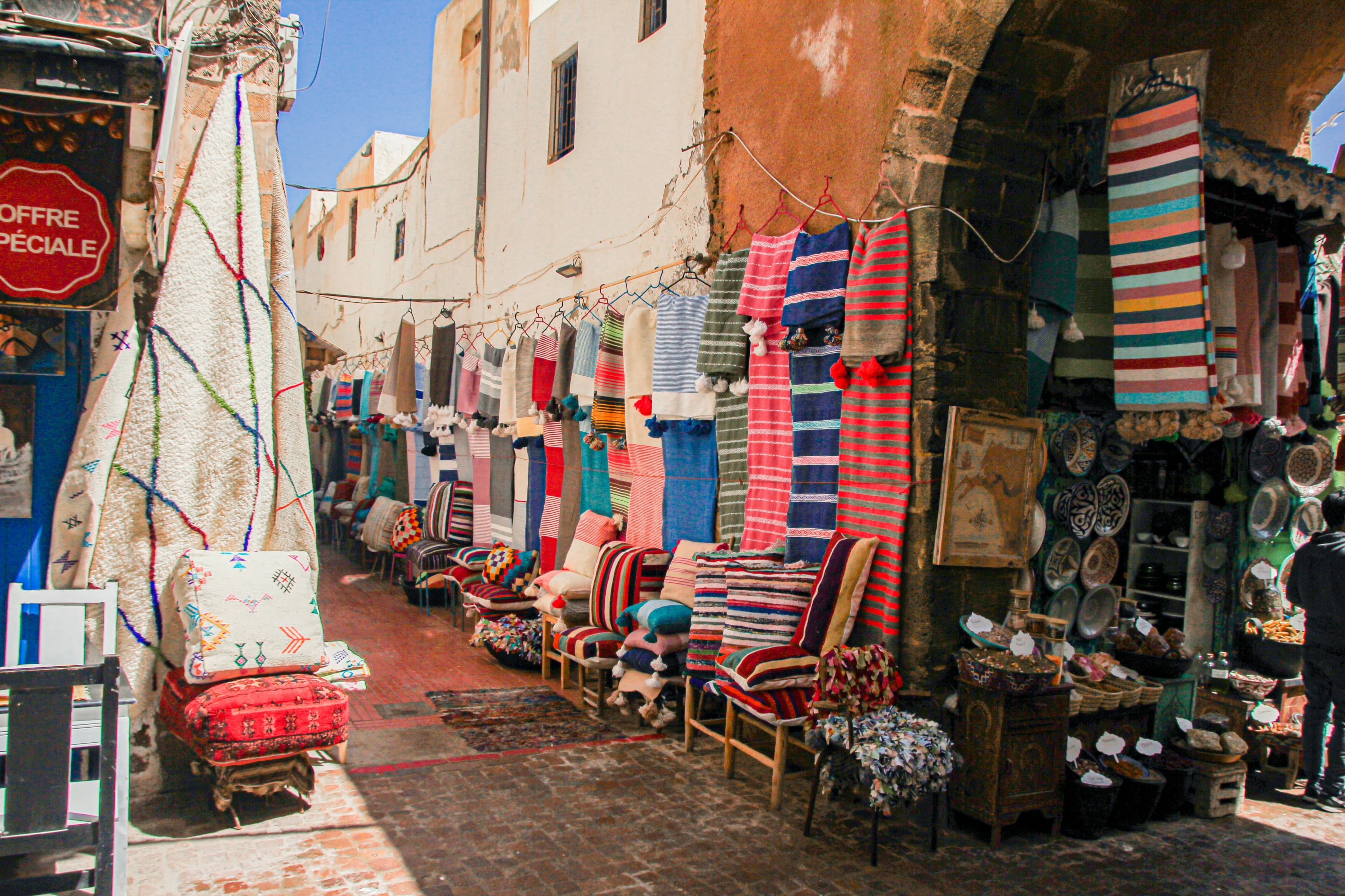 Essaouira medina souk with colorful textiles and ceramics — Morocco travel budget guide