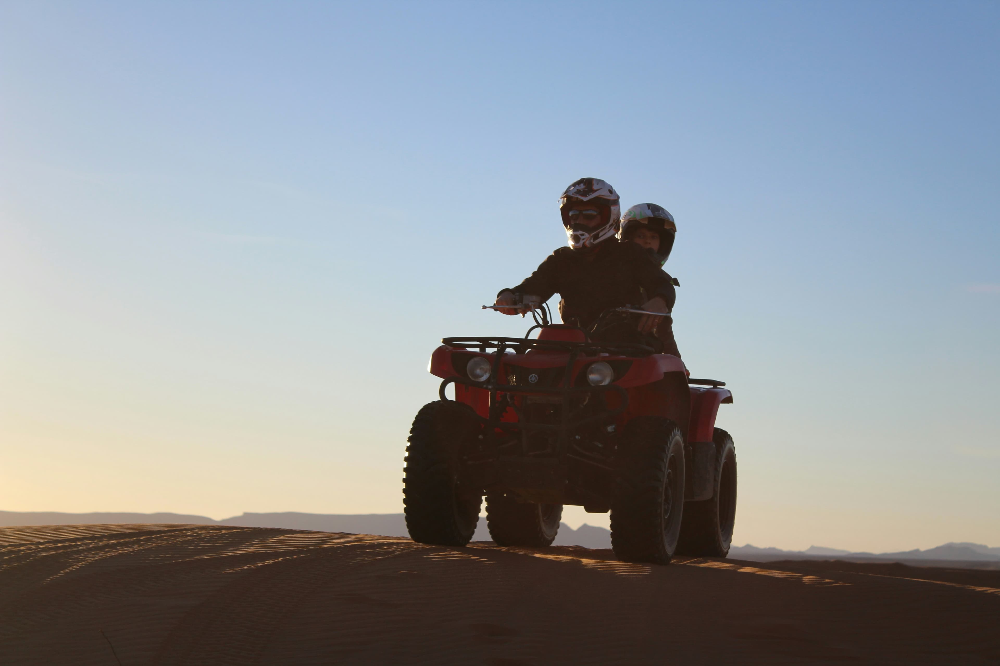 Quad bike on Sahara sand dunes at sunset, Merzouga Morocco
